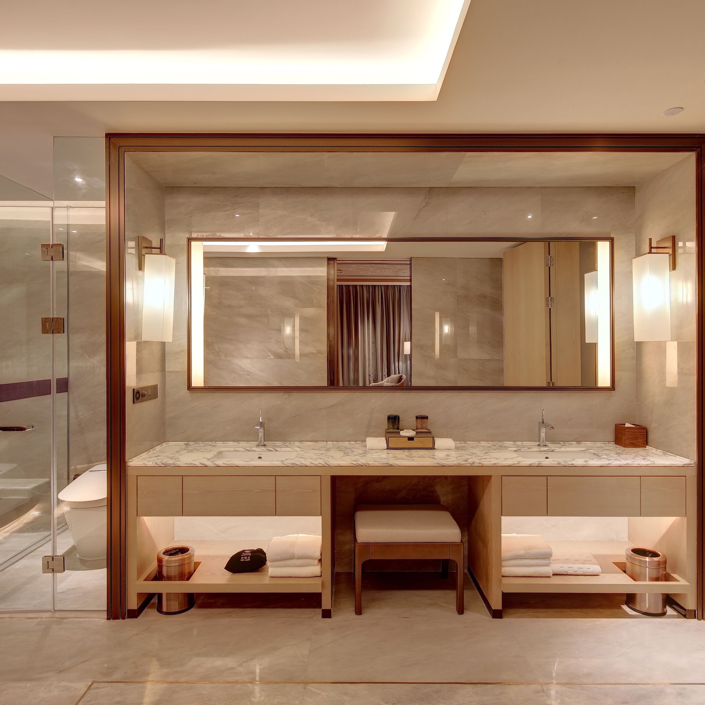 A modern bathroom with a large mirror, dual sinks, and a vanity area.