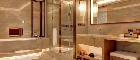 A modern bathroom with a glass-enclosed shower, a large mirror, and a marble floor.
