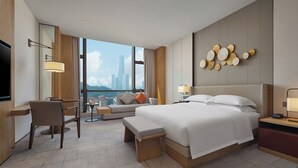 A modern hotel room with a large bed, a desk, a chair, and a TV. - Dongguan Dongcheng International Hotel (Dongguan)