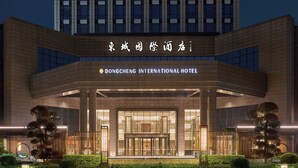 The Dongcheng International Hotel entrance with a modern design, featuring a glass facade and a well-lit entrance area. - Dongguan Dongcheng International Hotel (Dongguan)