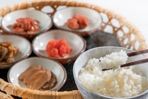 A variety of food items including white rice, pickled vegetables, and a dish with a reddish sauce, served in small bowls. - Komagatake Grand Hotel (Senboku)