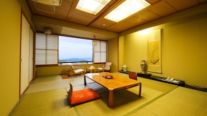 Een traditionele Japanse kamer met tatami vloerbedekking, een houten tafel en schuifdeuren.