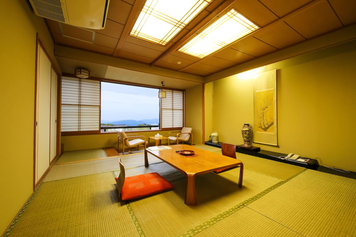A traditional Japanese-style room with tatami flooring, a wooden table, and sliding doors.
