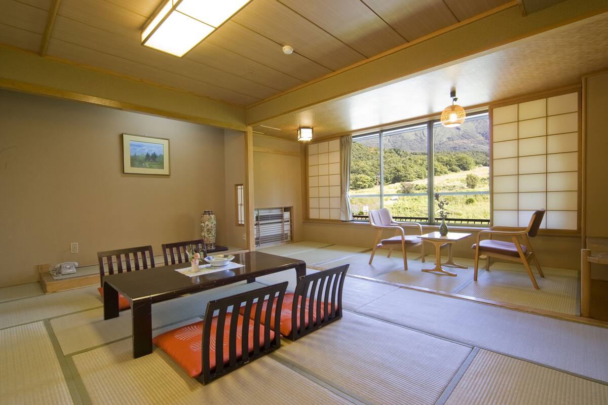 A traditional Japanese room with tatami flooring, a low wooden table, and shoji screens.