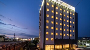A SuperHotel with multiple floors, a modern design, and a well-lit facade. - Super Hotel Kumamoto Yatsushiro (Yatsushiro)