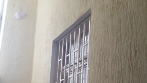 A set of outdoor stairs leading up to a building with a textured wall and a barred window. - New Generation Hostel Belgrade Center (Belgrade)
