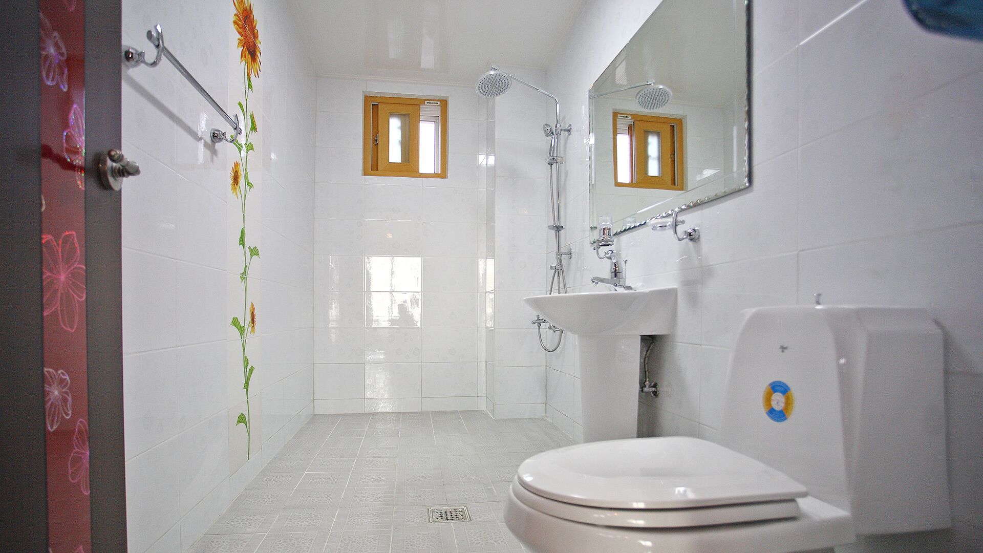 A bathroom with a toilet, sink, and shower.