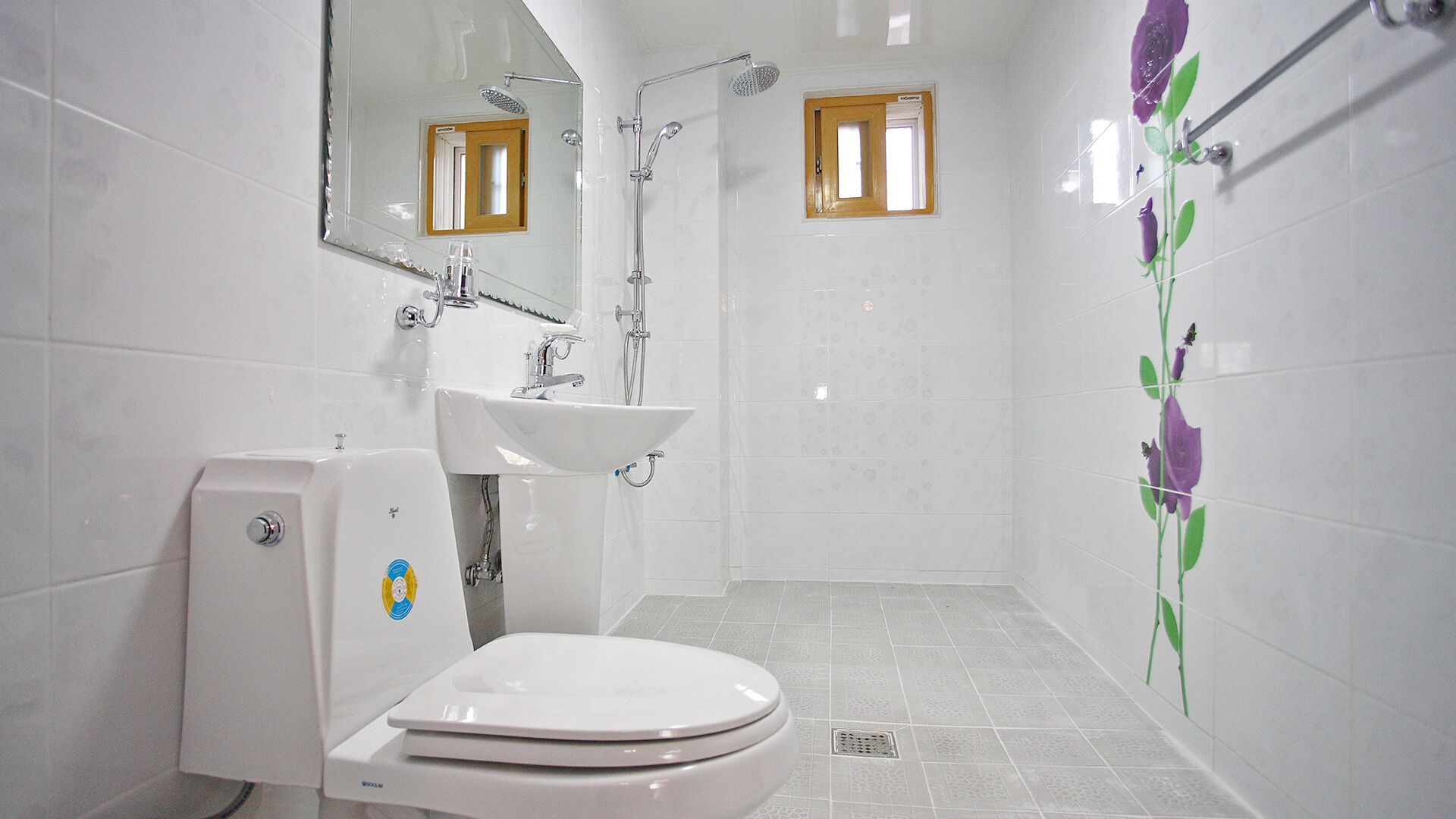 A bathroom with a toilet, sink, and shower.