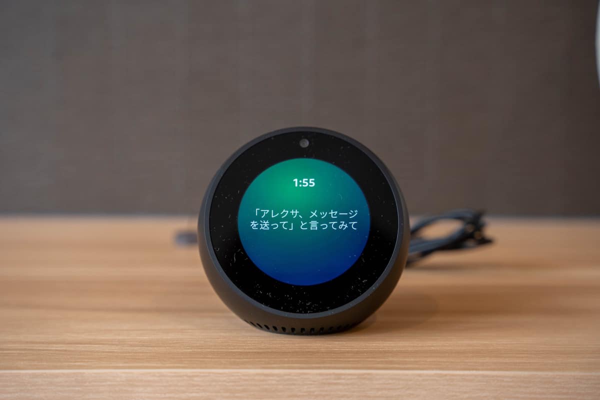 A smart speaker on a wooden surface.