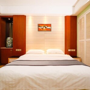 A modern bedroom with a large bed, wooden panel walls, and a framed artwork above the bed. - Guangzhou Superior Hotel (Guangzhou)