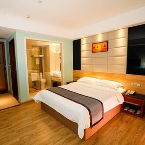 A hotel room with a bed, a bedside table with a phone, and a wall-mounted TV. - Guangzhou Superior Hotel (Guangzhou)