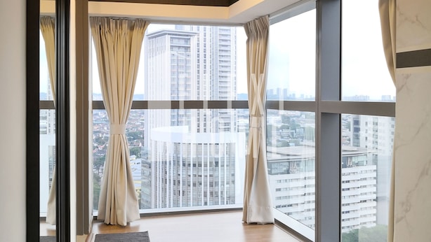 A spacious room with large windows, a wooden floor, and a view of high-rise buildings. - Pinnacle PJ by Flexihome (Petaling Jaya)