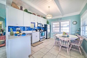 Enjoy cooking in this well-equipped kitchen with stainless steel appliances, a dining area, and natural light.