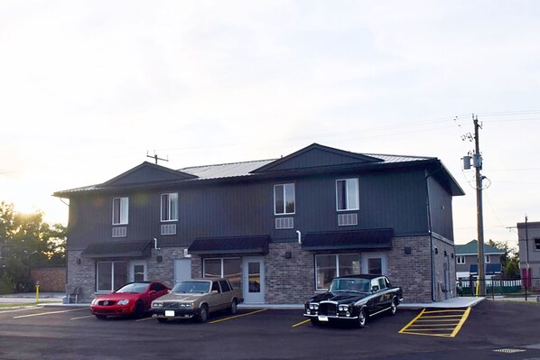 A two-story building with a parking lot in front. - Hotel Kent Chatham (Chatham-Kent)