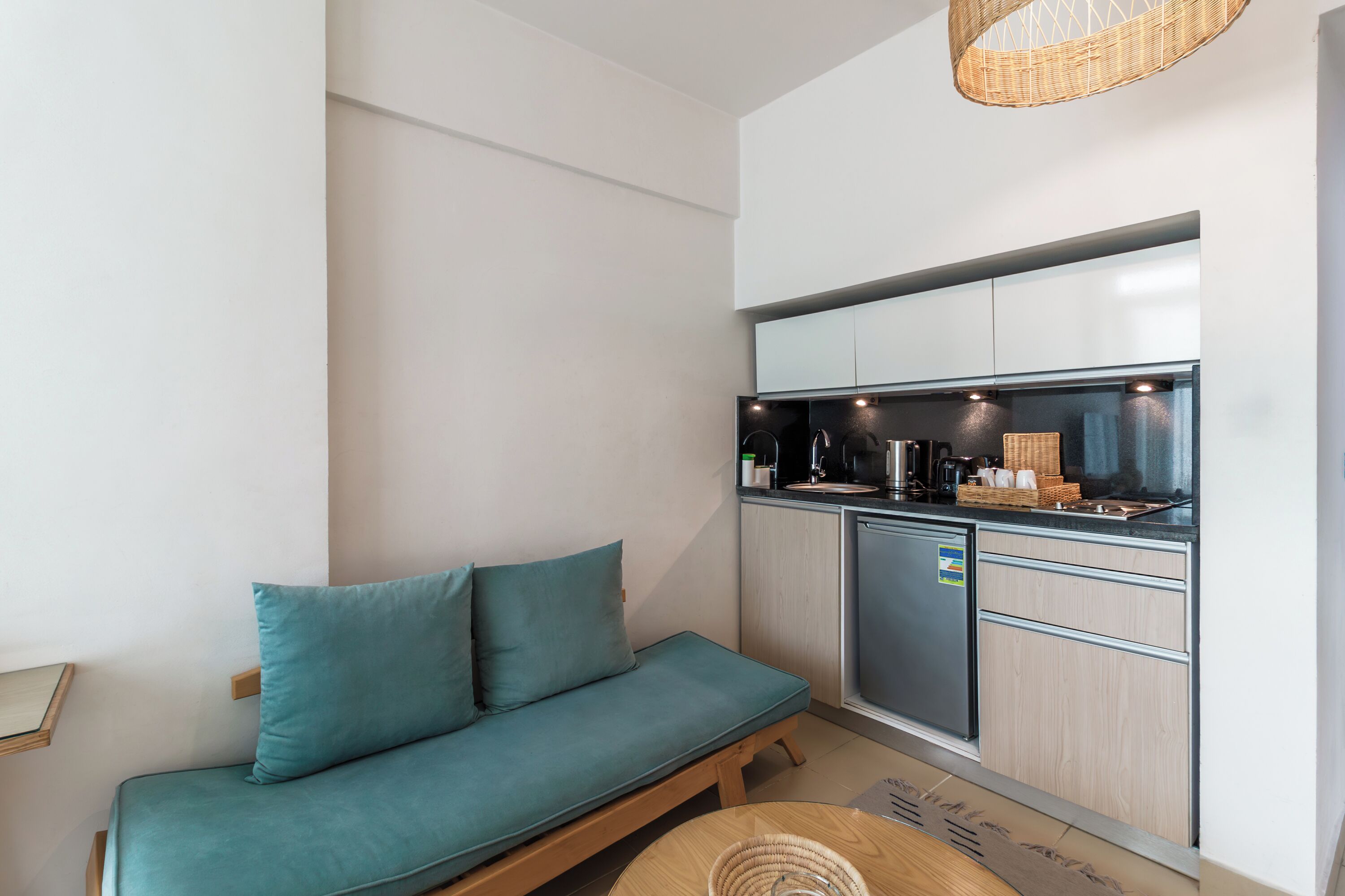 A compact kitchenette with a built-in oven, a coffee machine, and a small refrigerator.
