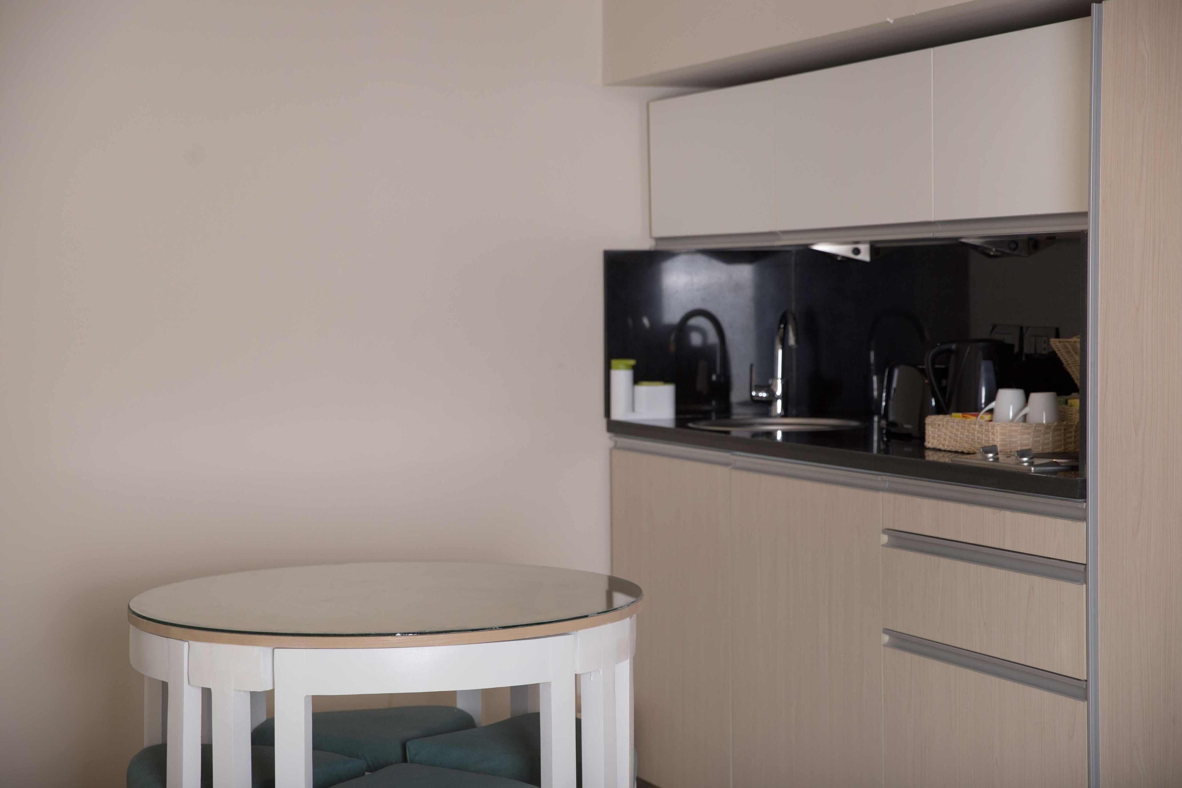 A compact kitchen with a round table and a built-in bench.