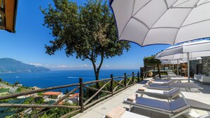 A terrace with sun loungers, umbrellas, and a view of the sea. - Villa Alba d' Oro - Historic Luxury Villa  (Amalfi)