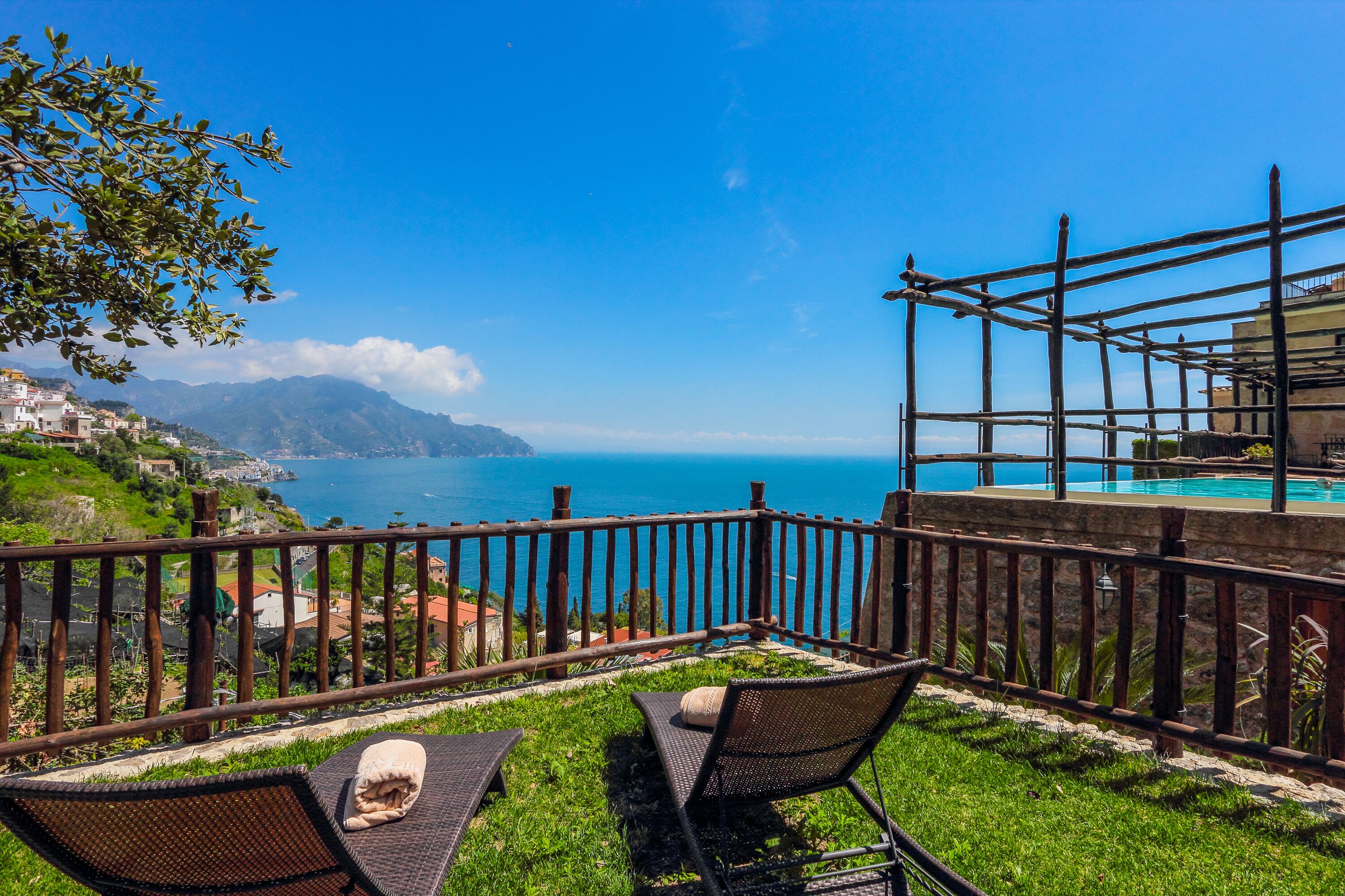 Une terrasse avec vue sur la mer, une piscine et un paysage montagneux.