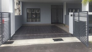 A modern building with a gated entrance, a tiled driveway, and a window with a metal grille. - Kota Laksamana Comfortable Crowd by Step-In (Malacca City)