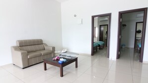 A living room with a sofa, a coffee table, and a door leading to a bathroom. - Kota Laksamana Comfortable Crowd by Step-In (Malacca City)