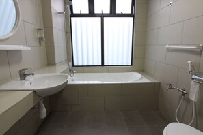 A bathroom with a sink, mirror, window, and toilet.