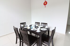 A dining table set with plates, bowls, and cups, surrounded by chairs.