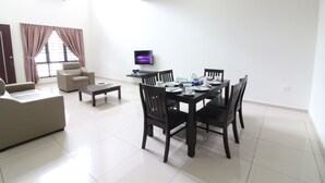 A modern living room with a dining area, a flat-screen TV, and a large window with curtains. - Kota Laksamana Comfortable Crowd by Step-In (Malacca City)