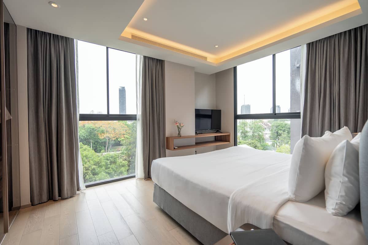 Une chambre d’hôtel moderne avec un grand lit, une télévision et une vue sur la ville.