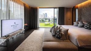 Une chambre d’hôtel moderne avec un grand lit, une télévision et une vue sur le panorama urbain.