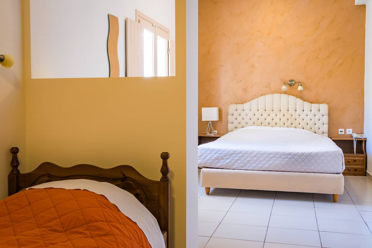 Un dormitorio con una cama de madera, cabecera blanca y una mesita de noche con una lámpara.