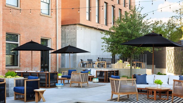 An outdoor patio area with seating, a pool, and string lights. - Kimpton Pittman Hotel – Downtown Dallas by IHG (Dallas)