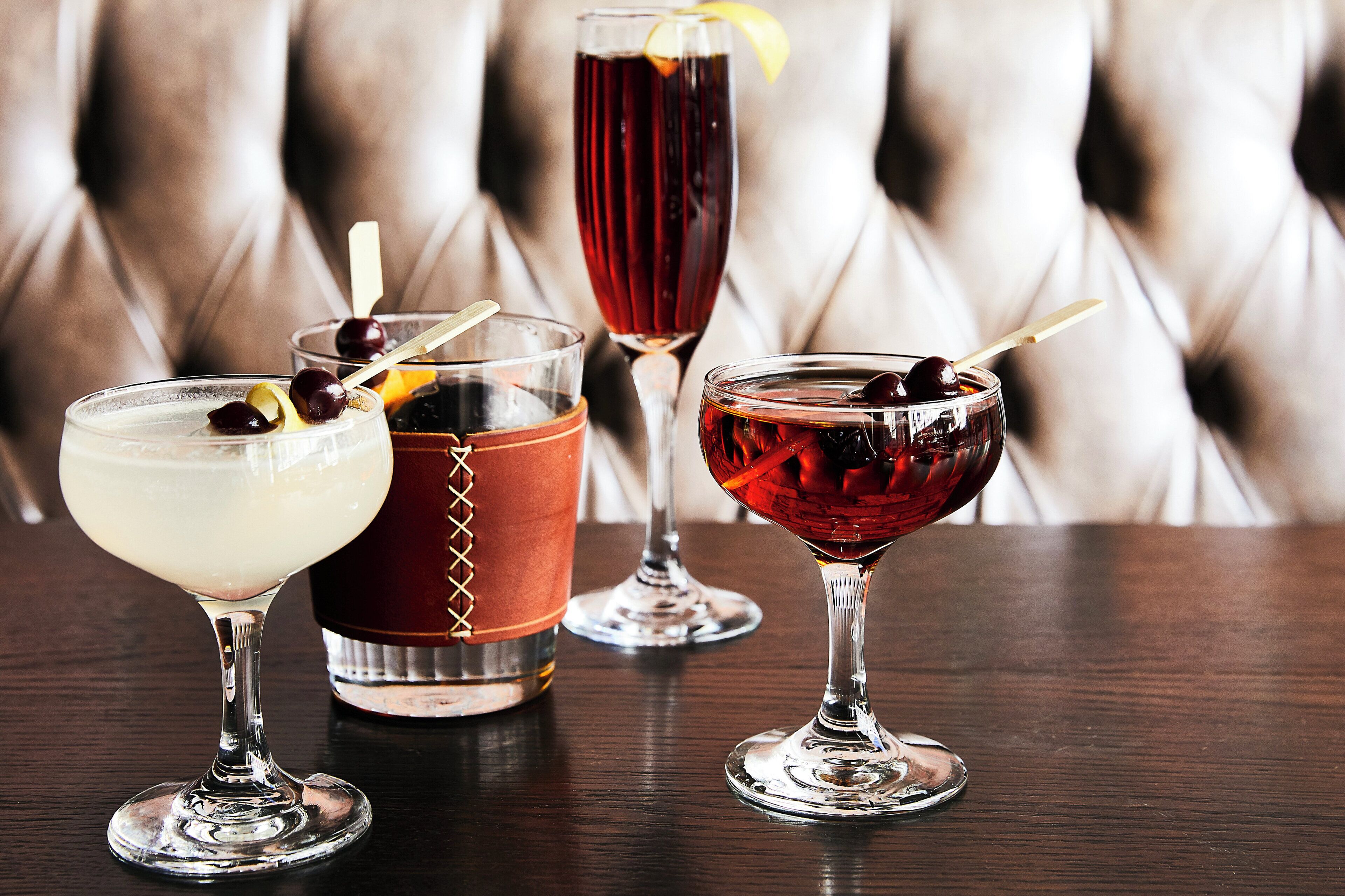Four different types of drinks served in various glassware on a table.
