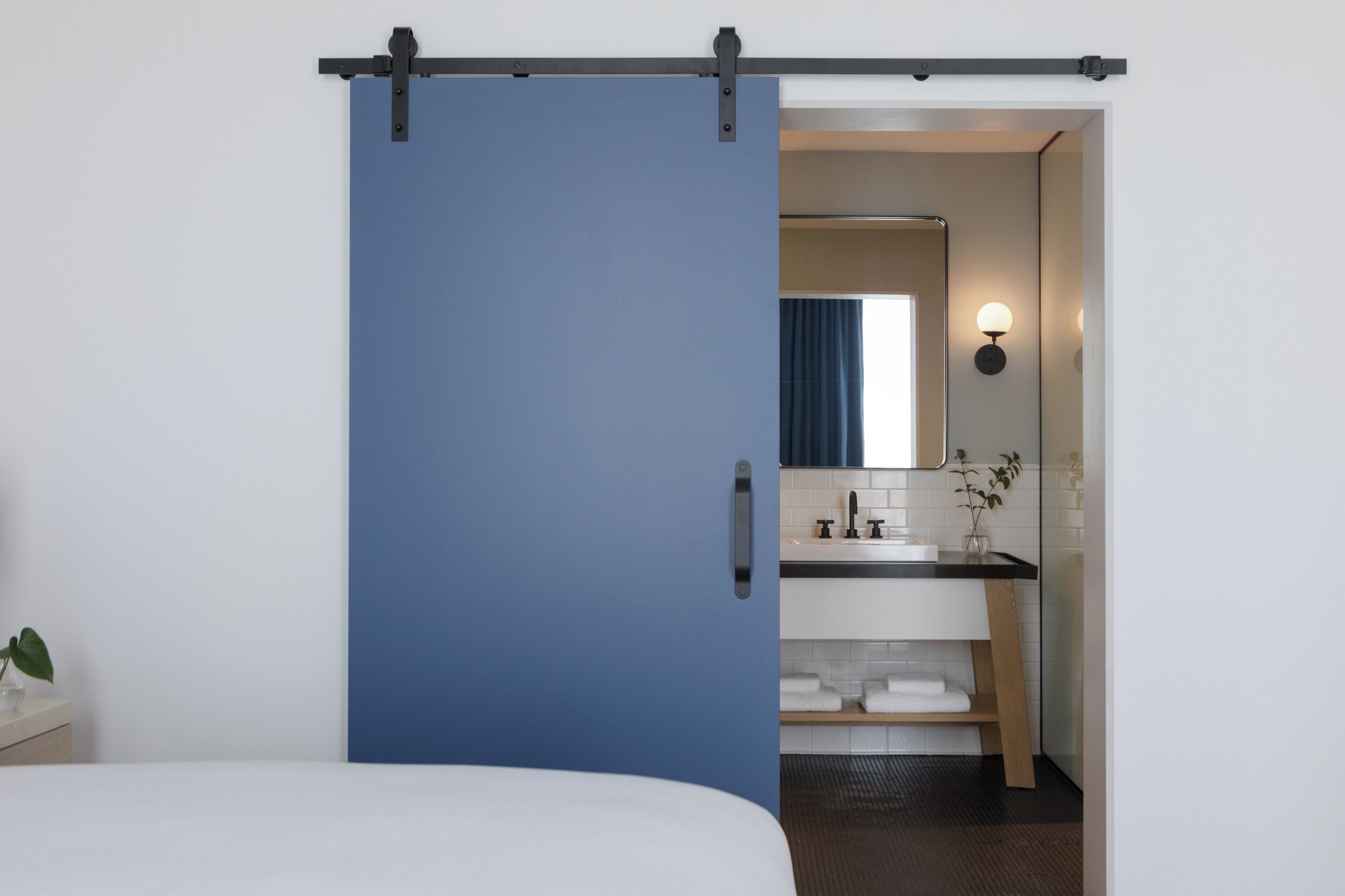 Una habitación de hotel con una puerta corredera que da a un baño.