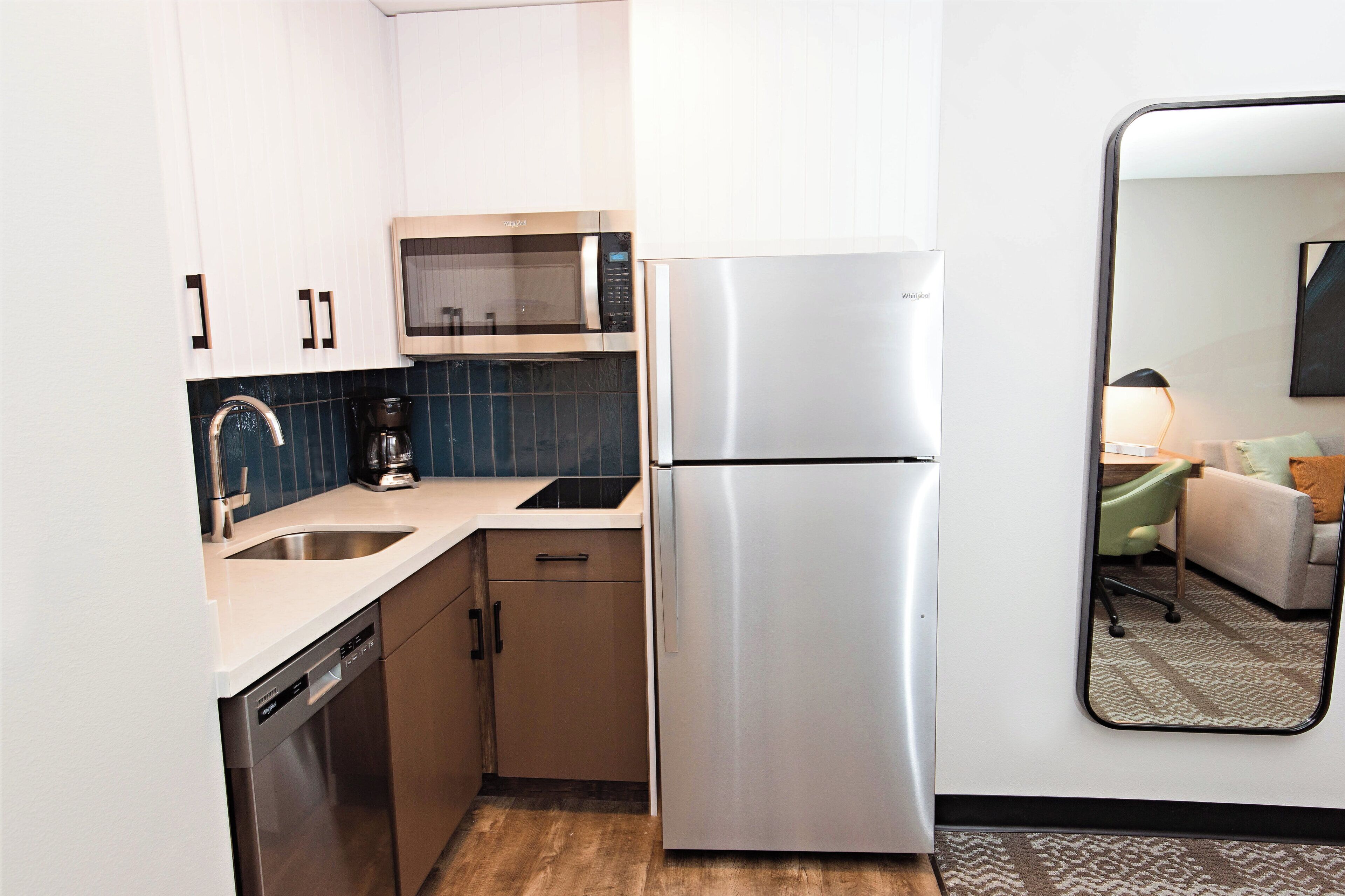 A compact kitchen with a dishwasher, microwave, and refrigerator.