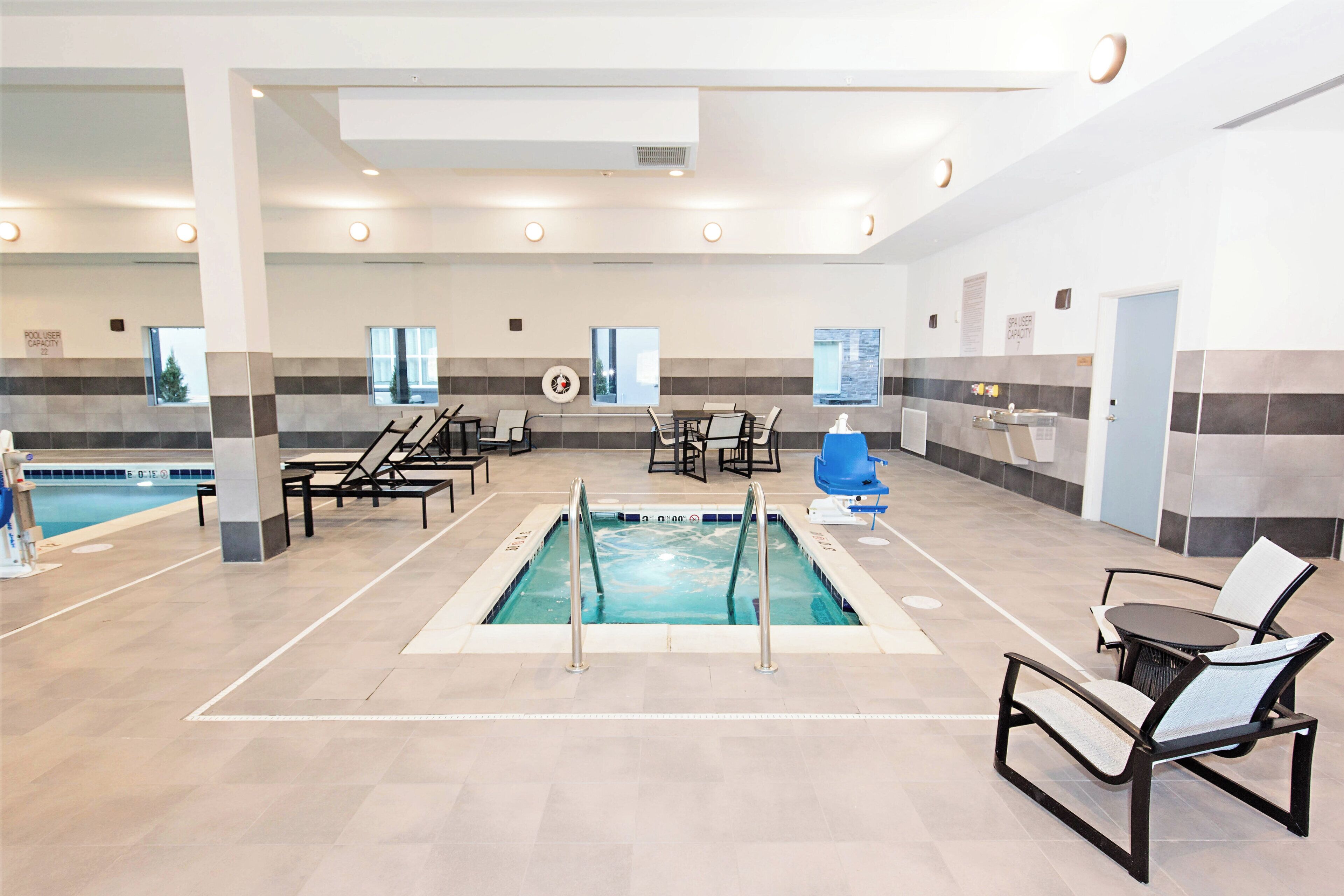 A swimming pool area with multiple lounge chairs and a changing room.