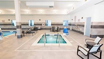 A swimming pool area with multiple lounge chairs and a changing room.