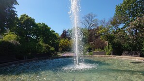 A clear water fountain in a park with trees and a clear sky. - On the edge of the historic old town, vacation apartment right in the center - 01 Family (Bautzen)