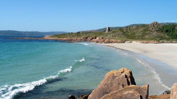 A coastal beach with clear waters, a sandy shore, and rocky outcrops. - Apartment Seaview in O Pindo (O Pindo)
