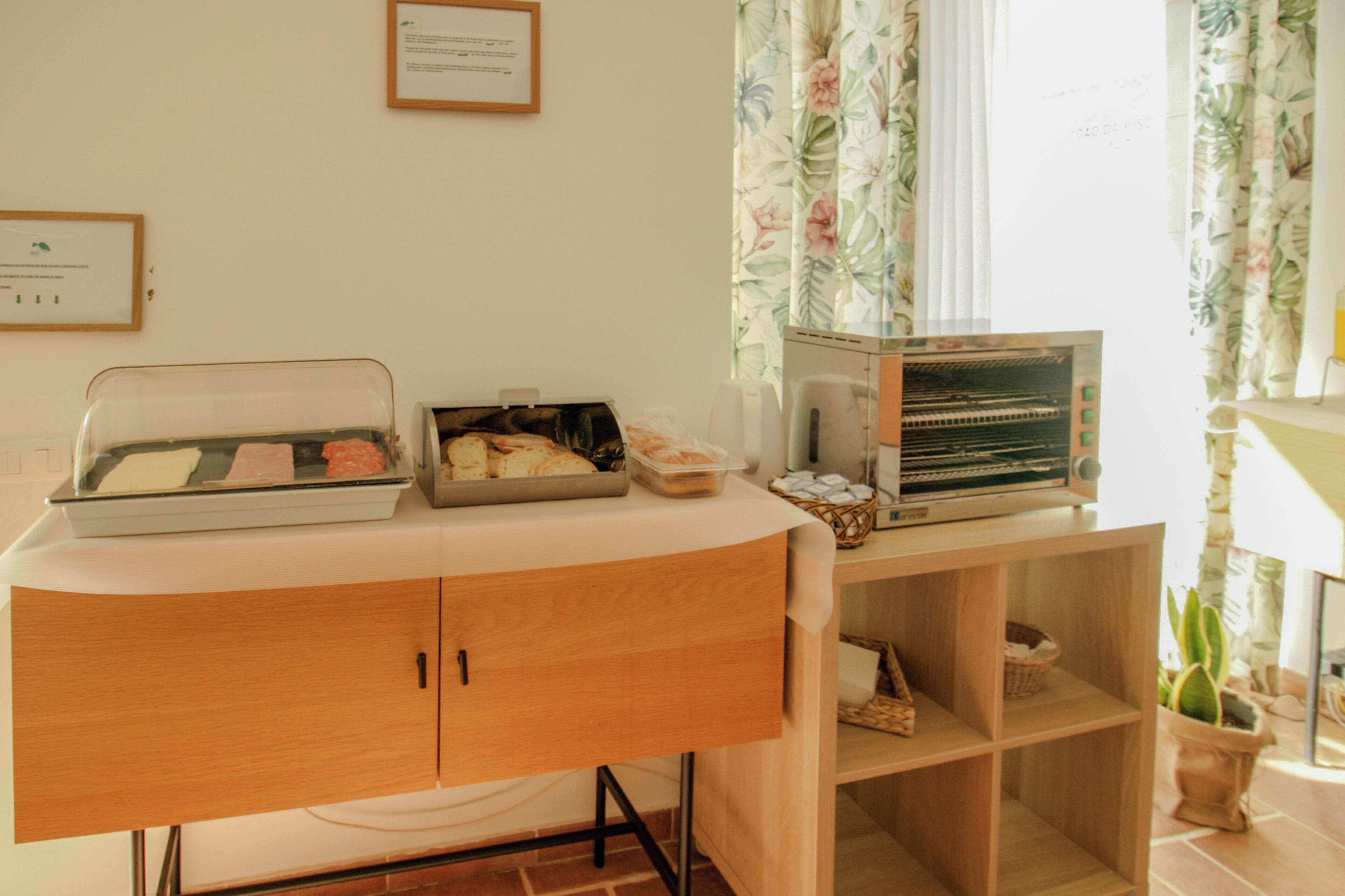 A kitchenette with a bread display, a toaster, and a coffee maker.