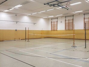A gymnasium with a basketball court, a volleyball net, and a basketball hoop. - Holiday Home in Großenbrode (Grossenbrode)