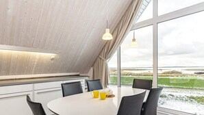 A modern dining area with a round table, black chairs, and a view of the outdoors.