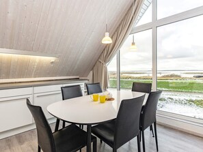 A modern dining area with a round table, black chairs, and a view of the outdoors.