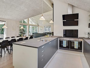 A modern kitchen with a large island, built-in appliances, and pendant lighting. - Holiday Home in Kappeln (Kappeln)