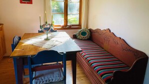 Una habitación acogedora con una mesa de madera, un banco y una ventana con cortinas.