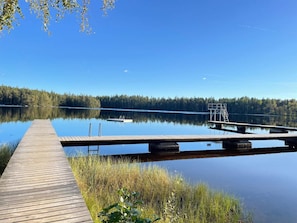A wooden dock extending into a calm lake, surrounded by dense forest. - 4 Person Holiday Home in Hallabro (Hallaröd)