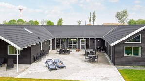 A building with a covered patio area, outdoor seating, and a grassy lawn. - Holiday Home in Kappeln (Kappeln)