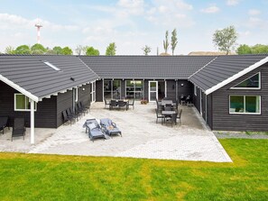 A building with a covered patio area featuring outdoor seating and a brick floor. - Holiday Home in Kappeln (Kappeln)