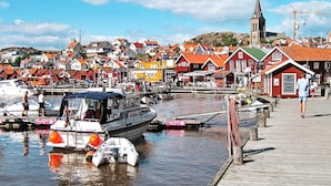 A harbor with boats, a wooden pier, and colorful buildings. - Holiday Home in Fjällbacka (Fjallbacka)
