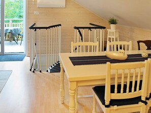 A dining area with a wooden table, chairs, and a staircase.