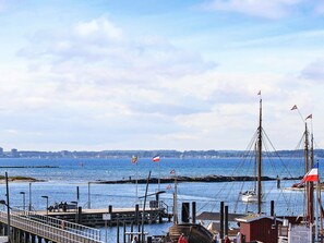 A harbor with boats, a pier, and a distant city skyline. - Holiday Home in Wendtorf (Wendtorf)